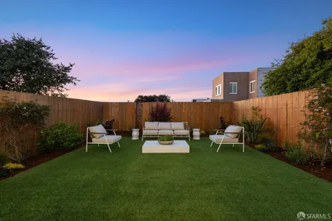 a view of a patio with couches table and chairs with plants and trees