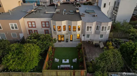 an aerial view of multiple houses with a yard