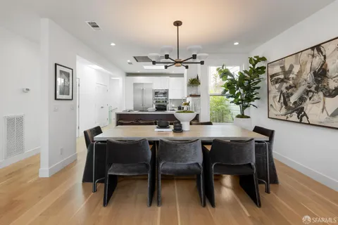 a kitchen with a dining table cabinets stainless steel appliances and a dining table