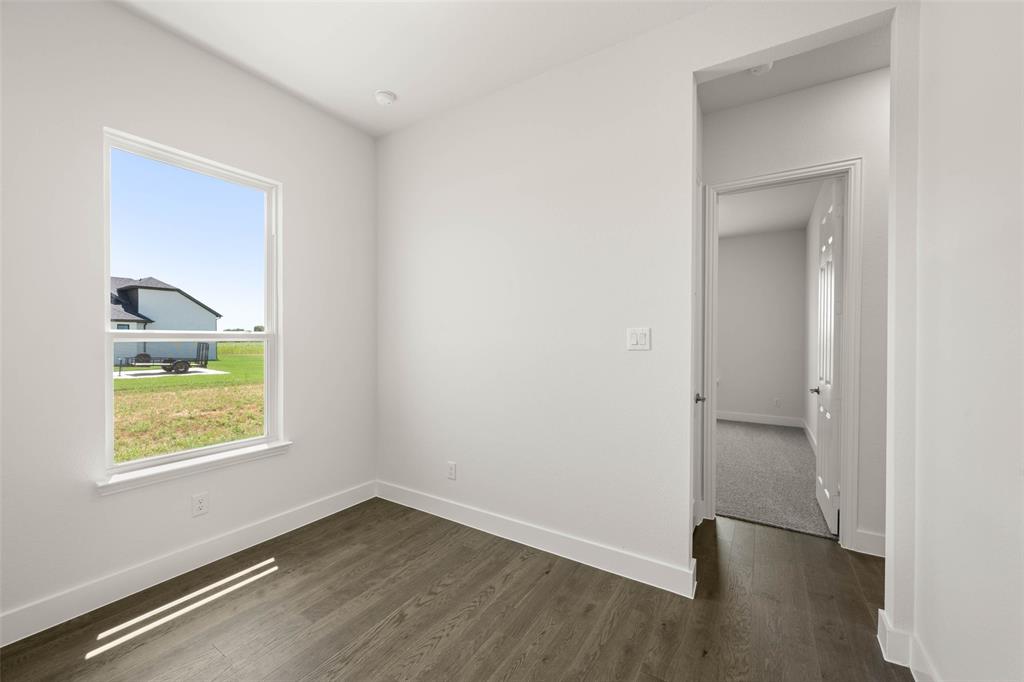 221 Olson Road Waxahachie, TX 75167 - Photo 15 of 24 an empty room with a window and wooden floor