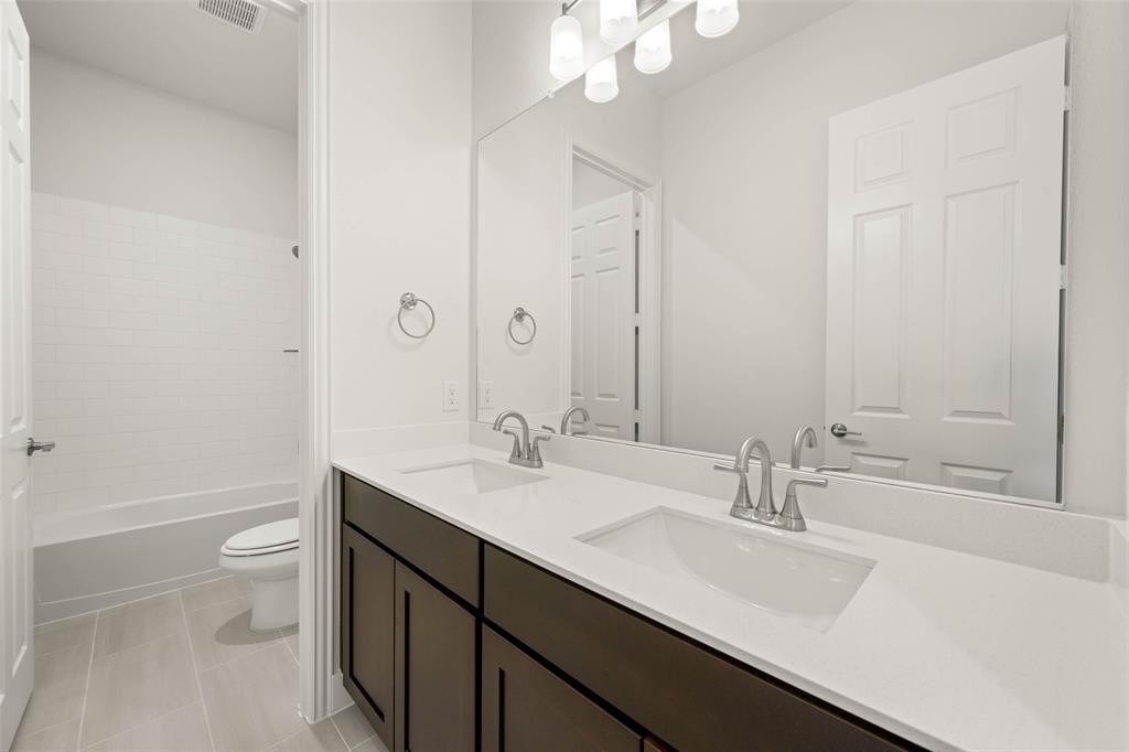 221 Olson Road Waxahachie, TX 75167 - Photo 16 of 24 a bathroom with a double vanity sink toilet and a mirror