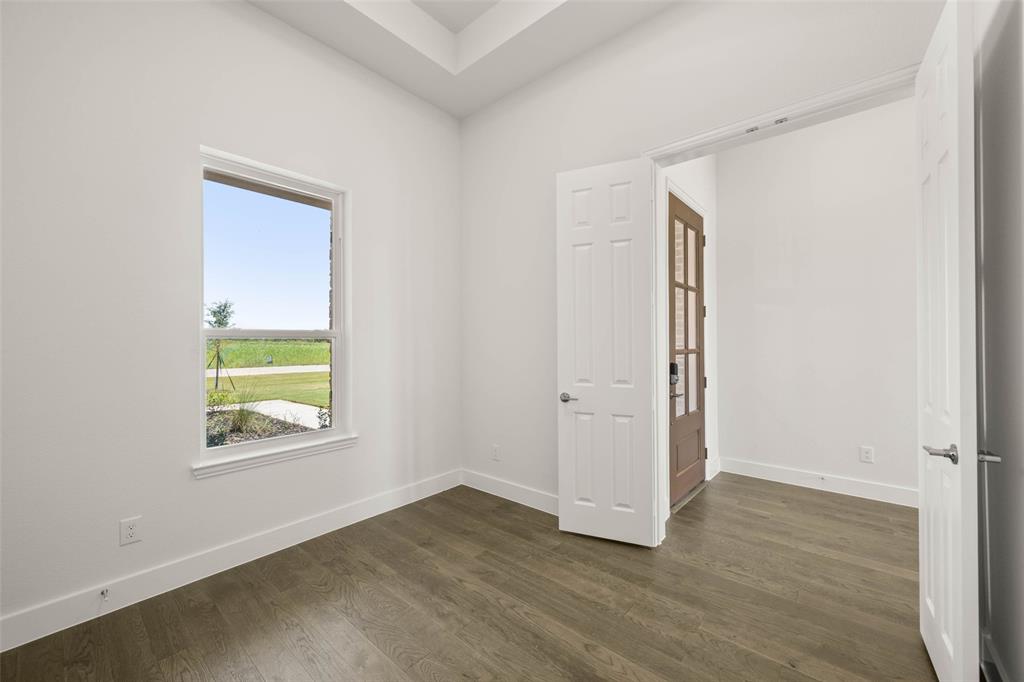 221 Olson Road Waxahachie, TX 75167 - Photo 4 of 24 an empty room with wooden floor and windows