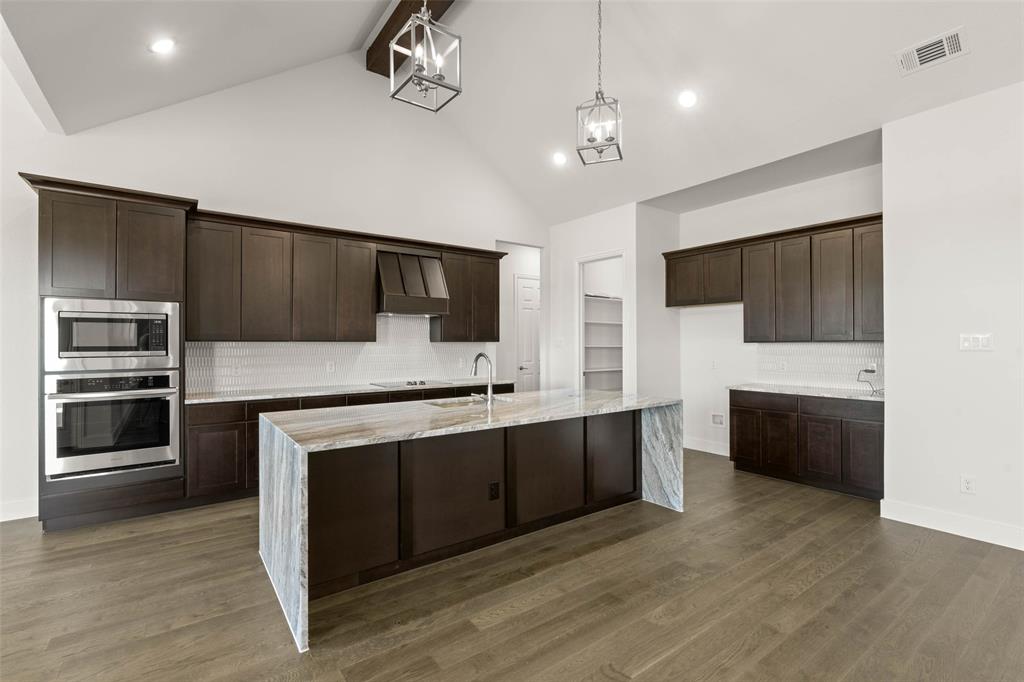 221 Olson Road Waxahachie, TX 75167 - Photo 8 of 24 a large kitchen with cabinets and stainless steel appliances