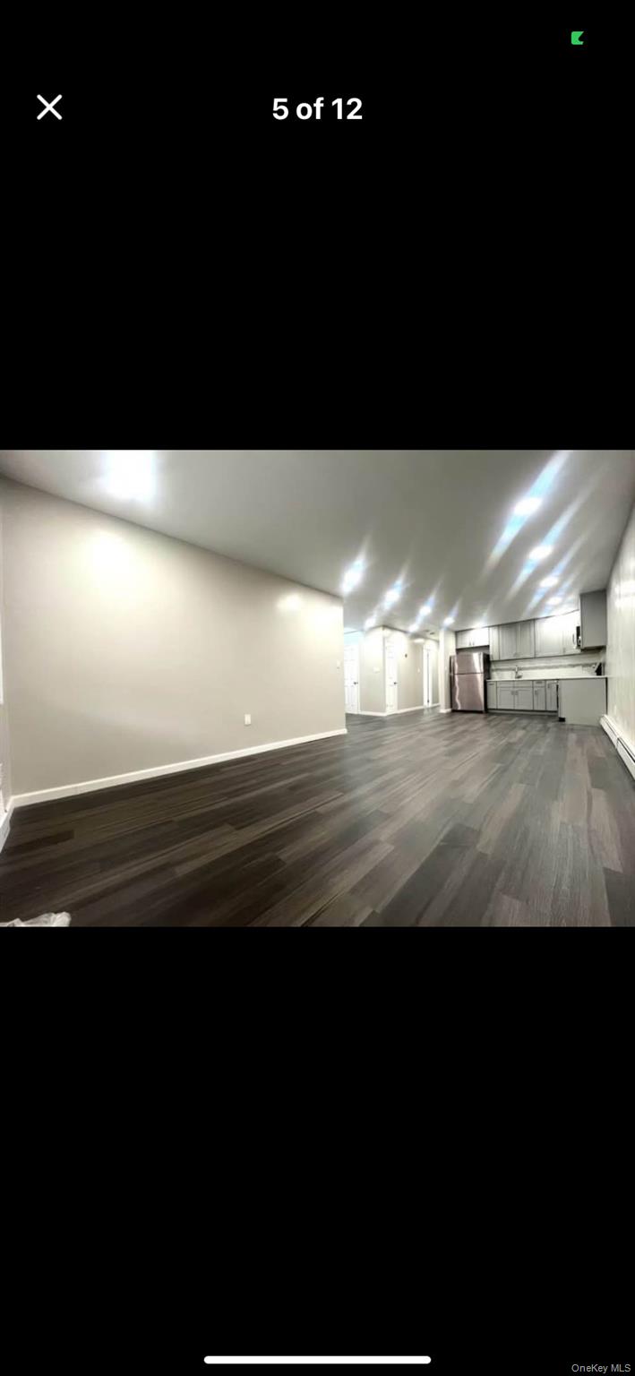 825 Ashford Street Brooklyn, NY 11207 - Photo 10 of 11 a view of an empty room and kitchen with a fan