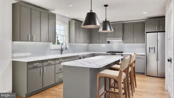 a kitchen with stainless steel appliances granite countertop a sink a stove a refrigerator and island with wooden floor