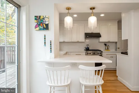a kitchen with a dining table chairs and a window