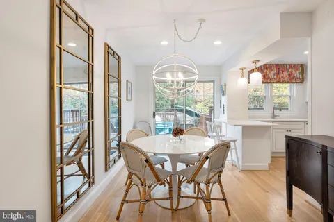 a view of a dining room with furniture a chandelier and wooden floor