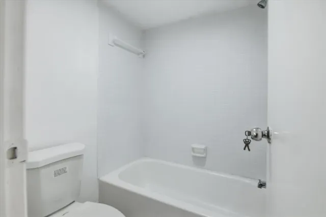 a white bath tub sitting next to a white toilet