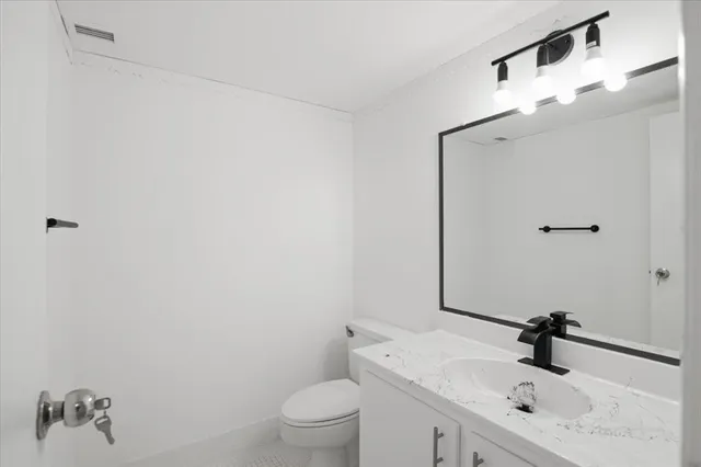 a bathroom with a sink a toilet and mirror