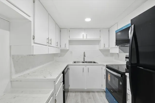 a kitchen with white cabinets and stainless steel appliances