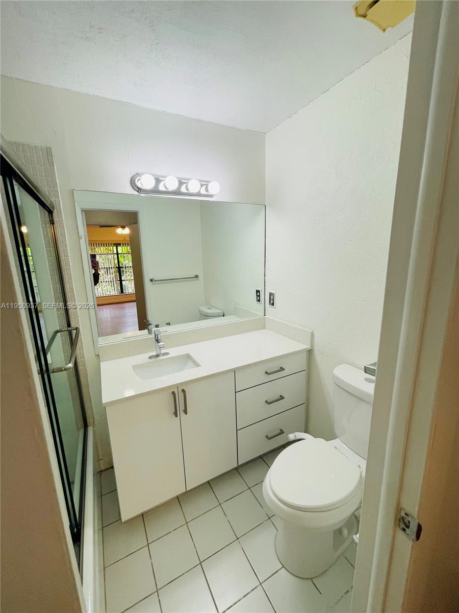 6425 Southwest 116th Place, Unit E Miami, FL 33173 - Photo 11 of 16 a bathroom with a sink a toilet and mirror