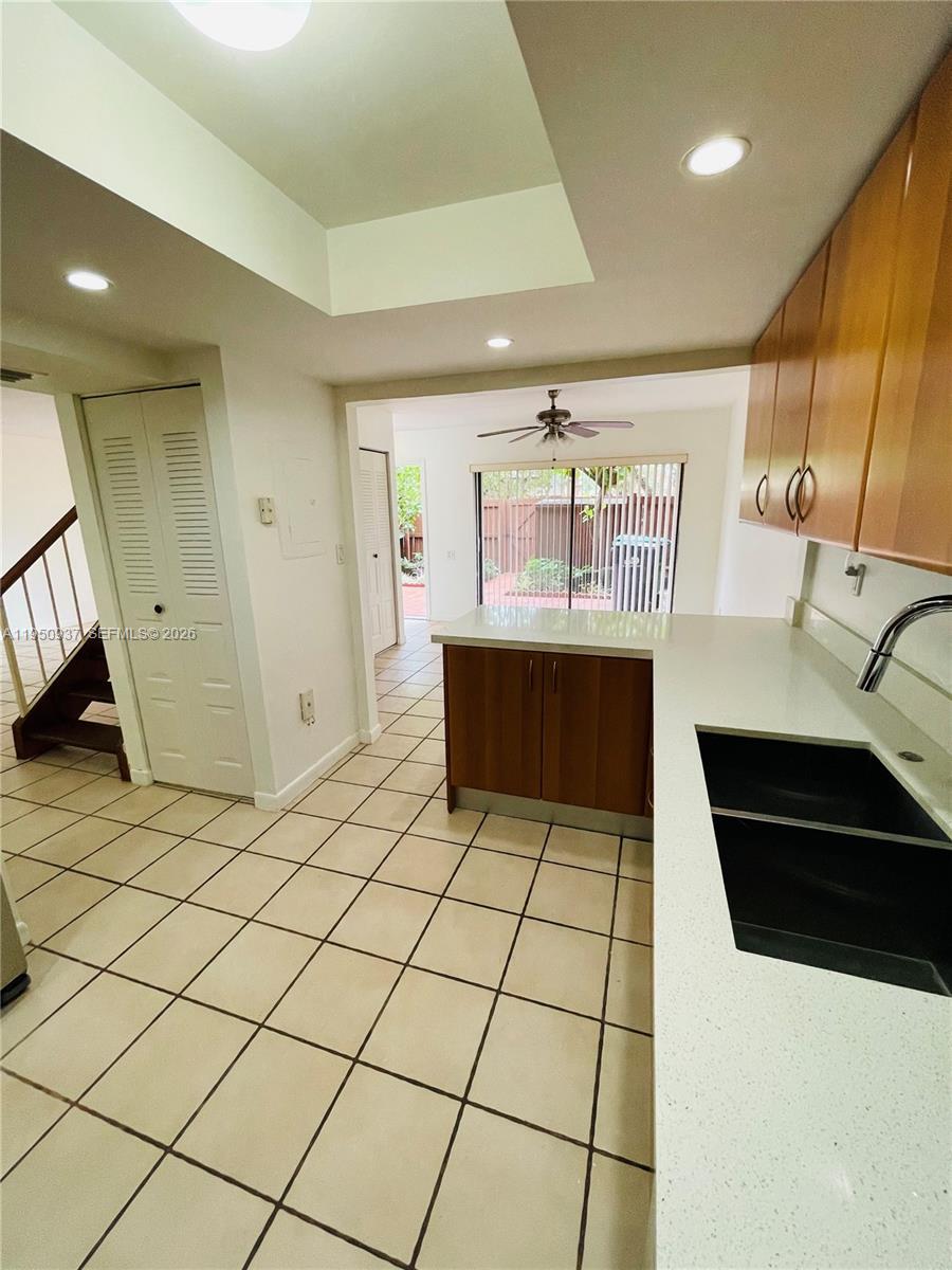 6425 Southwest 116th Place, Unit E Miami, FL 33173 - Photo 8 of 16 a kitchen with stainless steel appliances a sink a stove a microwave a refrigerator and cabinets