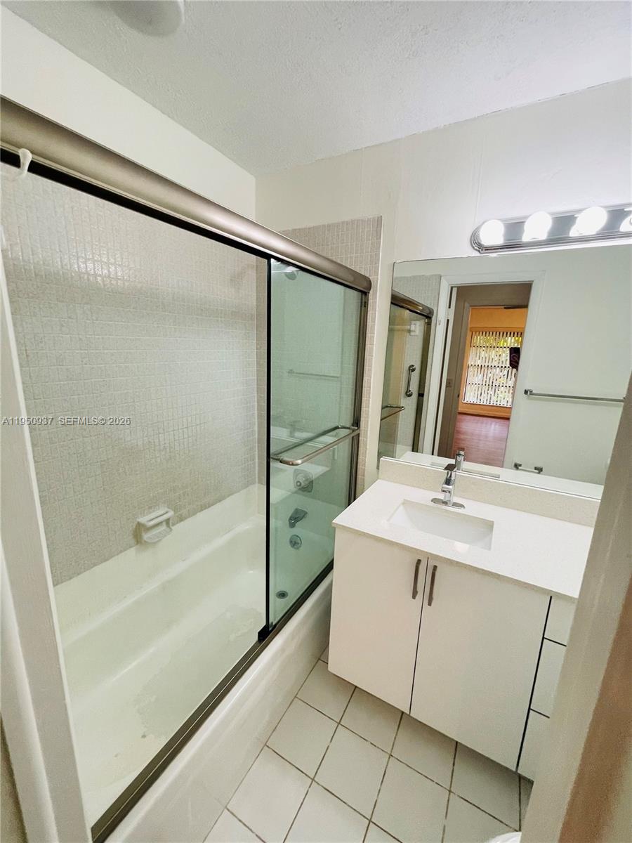 6425 Southwest 116th Place, Unit E Miami, FL 33173 - Photo 10 of 16 a bathroom with a sink a mirror and a bathtub