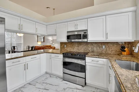 a kitchen with white cabinets stainless steel appliances and sink