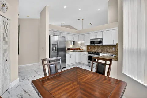 a kitchen with stainless steel appliances granite countertop a refrigerator stove microwave and sink