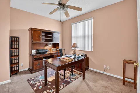 a view of a workspace with furniture and a window