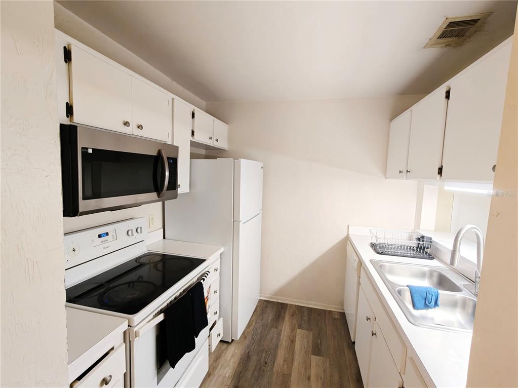 4000 Southwest 23rd Street, Unit 5207 ROOM B Gainesville, FL 32608 - Photo 20 of 23 a kitchen with stainless steel appliances a stove a microwave and a sink