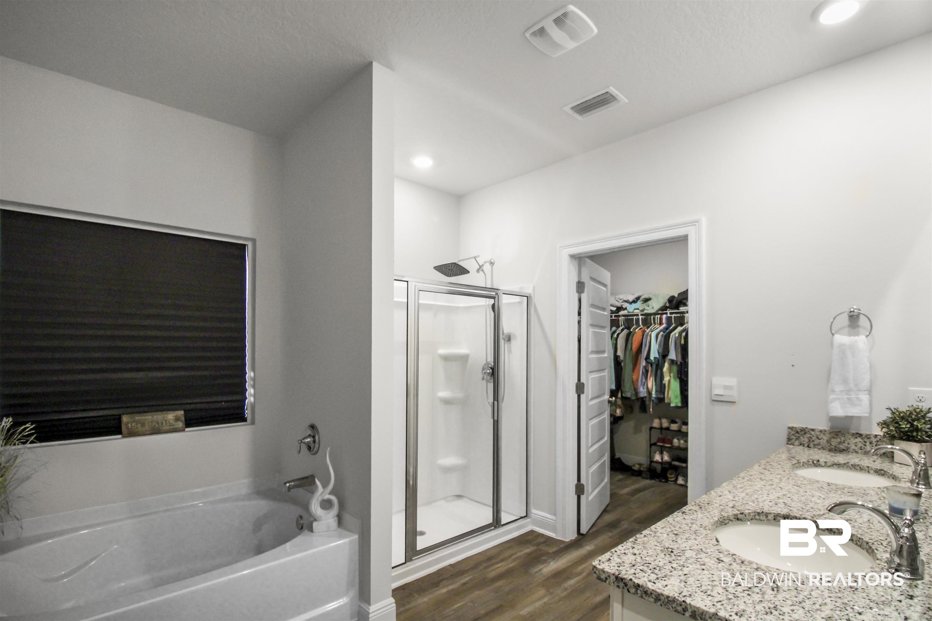 12523 Pheasant Run Elberta, AL 36530 - Photo 20 of 43 Full bath with a walk in closet, a bath, double vanity, a shower stall, and dark wood finished floors