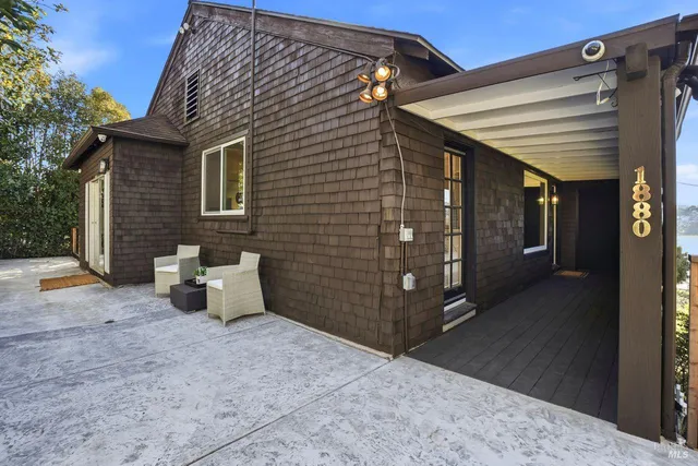 a view of balcony with wooden floor and fence next to a yard