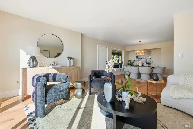 a dining room with wooden floor a chandelier a glass table and chairs