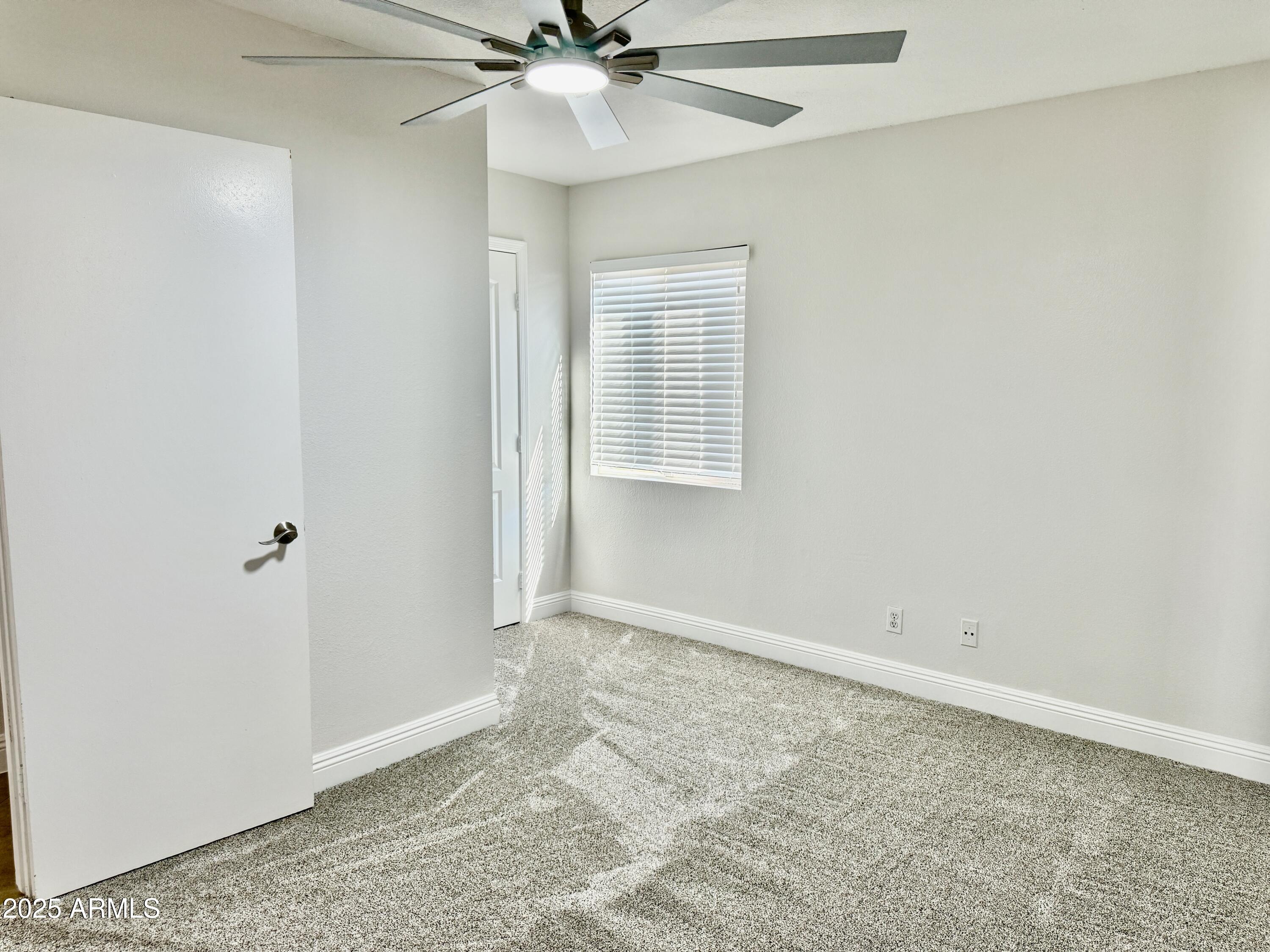 1213 East Tonto Lane Phoenix, AZ 85024 - Photo 15 of 19 an empty room with a ceiling fan and a window