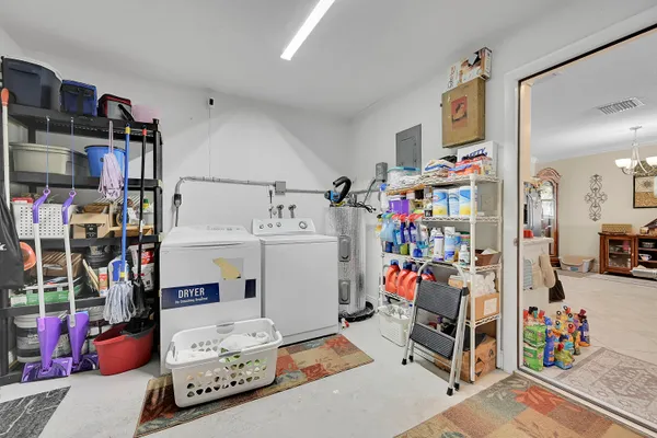 a utility room with fridge dryer and bicycles