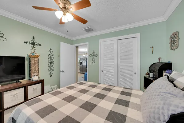 a bedroom with a bed and a flat tv screen on dresser