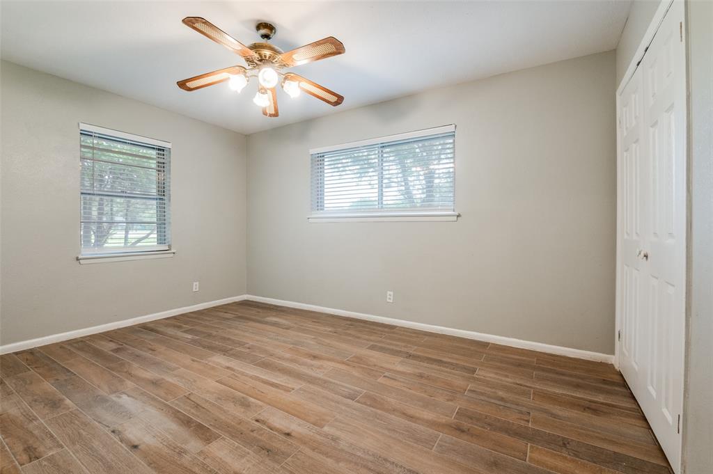 1533 East Springcrest Circle Lancaster, TX 75134 - Photo 18 of 25 Interior room featuring wood-look tile flooring, light neutral walls, and a ceiling fan with integrated lighting