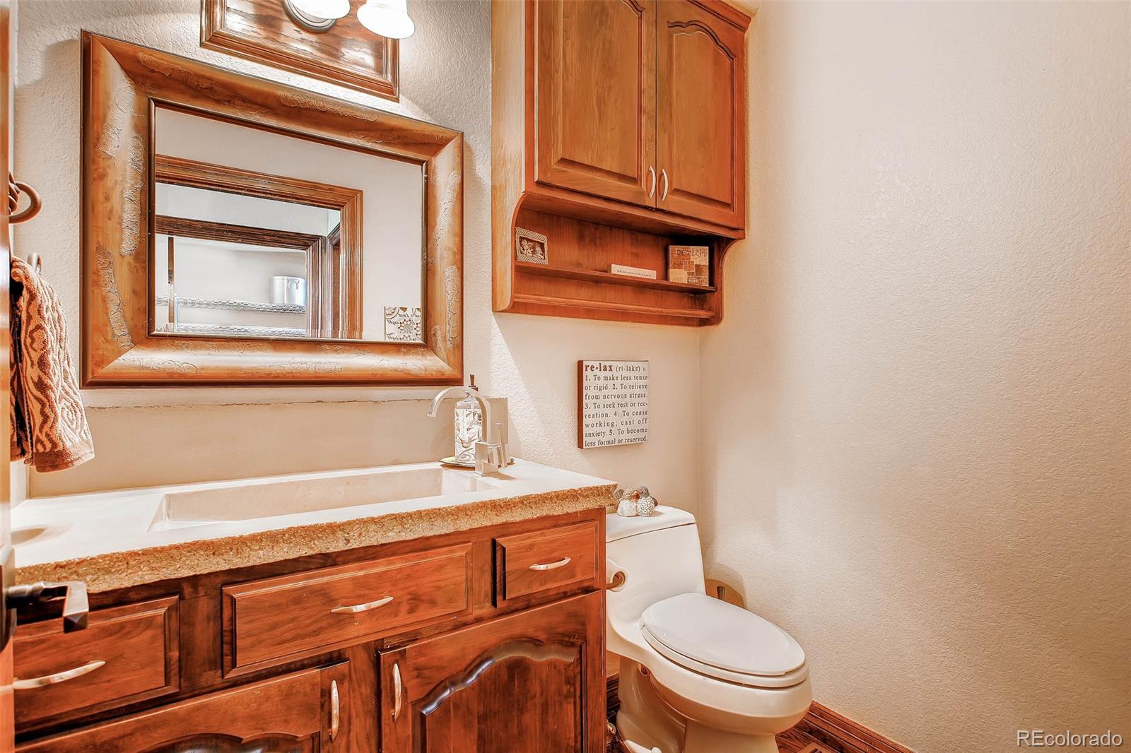 15241 Shadow Mountain Ranch Road Larkspur, CO 80118 - Photo 13 of 31 a bathroom with a toilet a sink and mirror