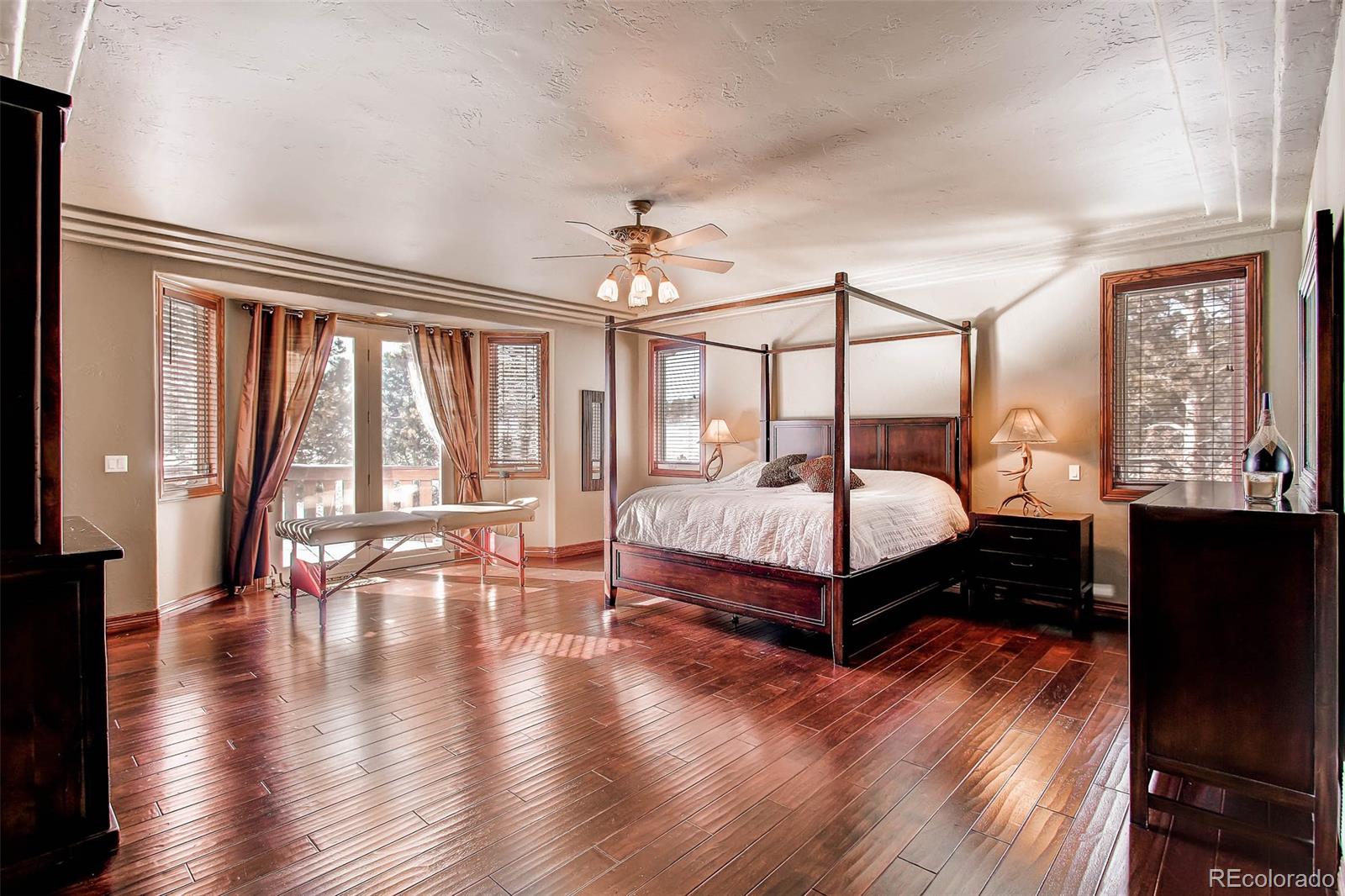 15241 Shadow Mountain Ranch Road Larkspur, CO 80118 - Photo 14 of 31 a bedroom with a large bed and a large window