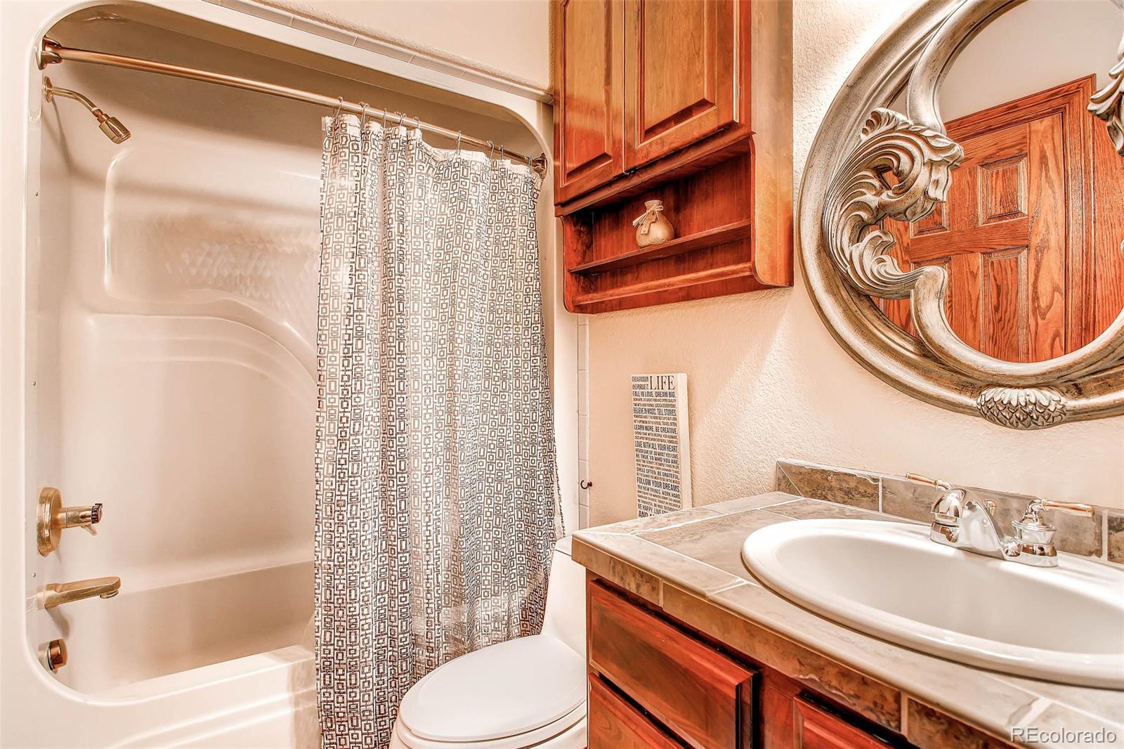 15241 Shadow Mountain Ranch Road Larkspur, CO 80118 - Photo 18 of 31 a bathroom with a sink toilet and shower