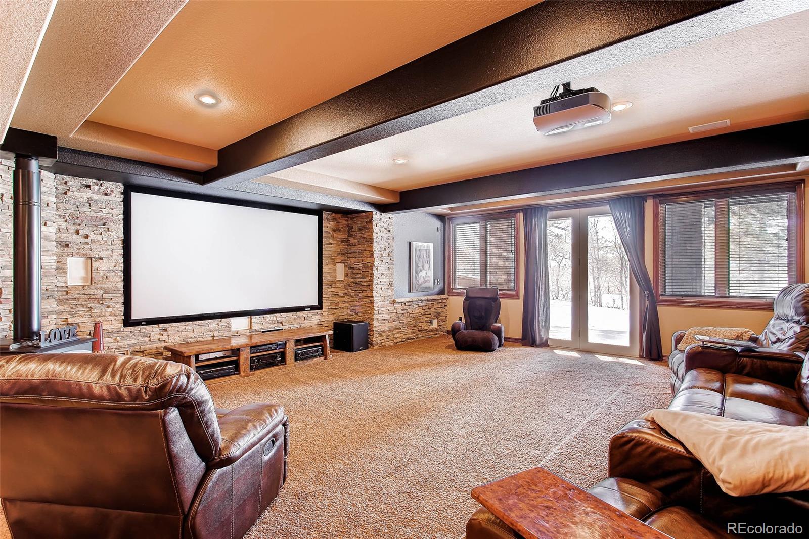15241 Shadow Mountain Ranch Road Larkspur, CO 80118 - Photo 20 of 31 a living room with furniture ceiling fan and a large window
