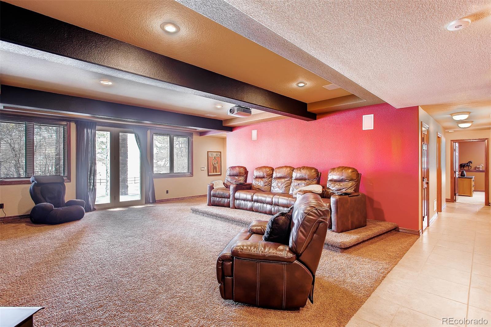 15241 Shadow Mountain Ranch Road Larkspur, CO 80118 - Photo 22 of 31 a living room with furniture a ceiling fan and a large window