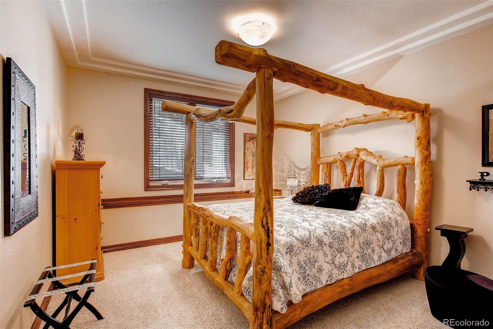 15241 Shadow Mountain Ranch Road Larkspur, CO 80118 - Photo 25 of 31 a bedroom with a bed and ceiling fan