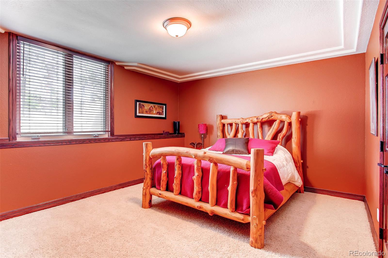 15241 Shadow Mountain Ranch Road Larkspur, CO 80118 - Photo 26 of 31 a bedroom with a bed and a window