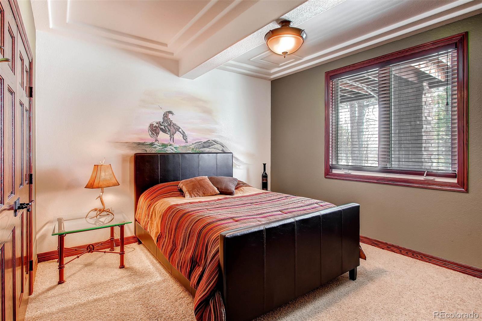 15241 Shadow Mountain Ranch Road Larkspur, CO 80118 - Photo 27 of 31 a bedroom with a bed and a window