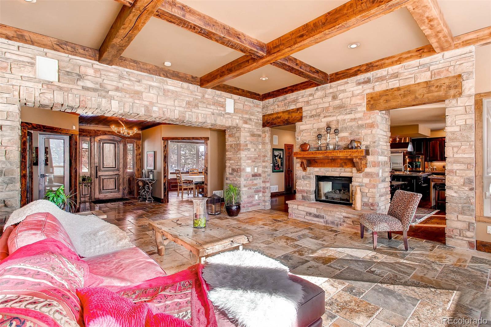 15241 Shadow Mountain Ranch Road Larkspur, CO 80118 - Photo 5 of 31 a living room with furniture a fireplace and a table