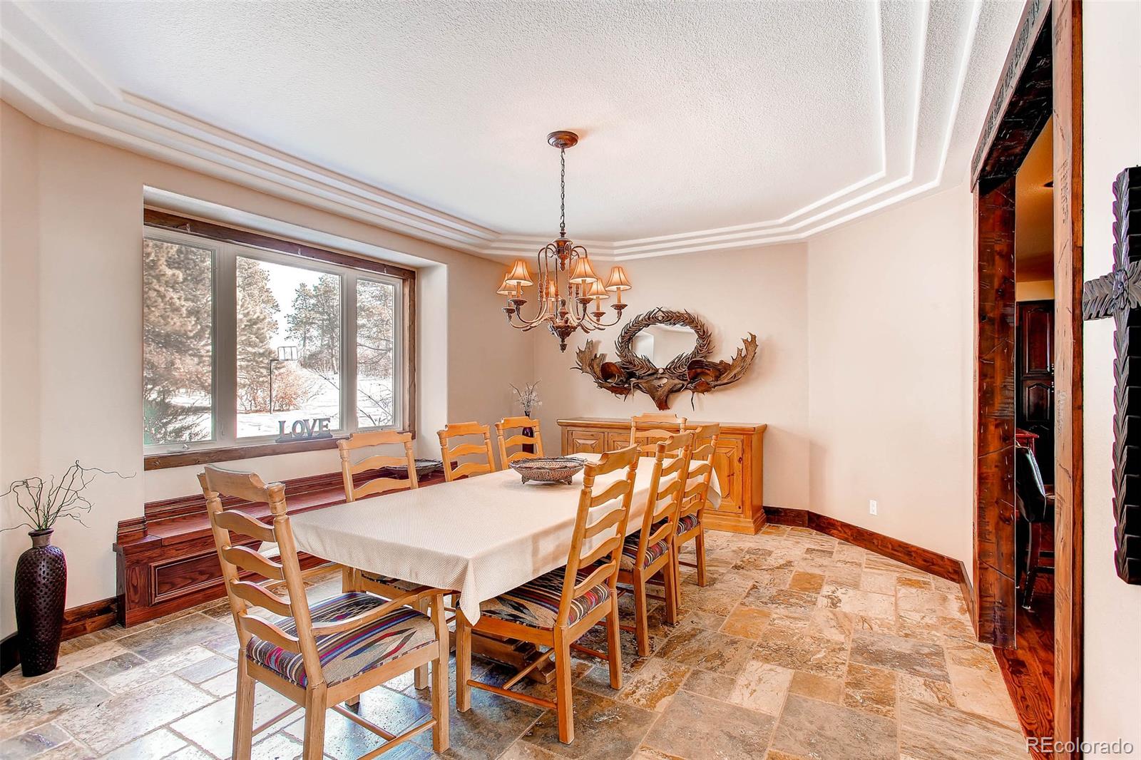 15241 Shadow Mountain Ranch Road Larkspur, CO 80118 - Photo 6 of 31 a dining room with furniture a chandelier and a rug