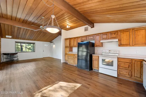 a kitchen with stainless steel appliances granite countertop a refrigerator a stove and a wooden floors