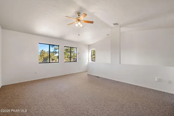 an empty room with window and ceiling fan