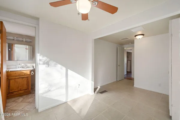 wooden floor with a chandelier fan and a kitchen view
