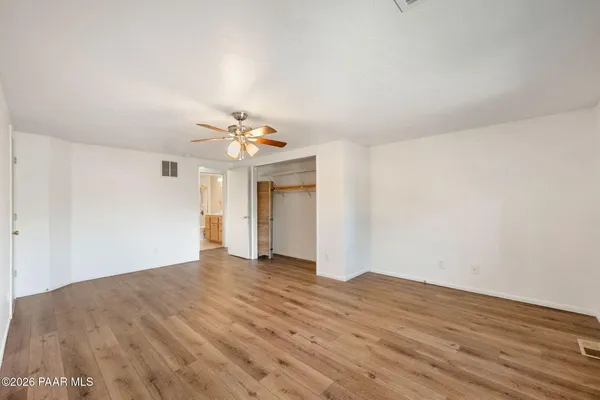a view of a room with wooden floor and ceiling fan