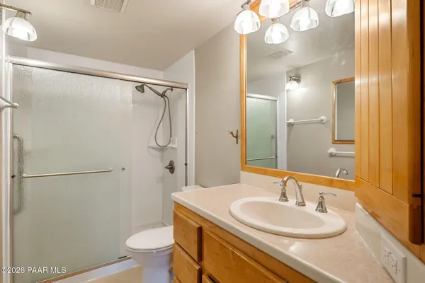 a bathroom with a granite countertop sink toilet a mirror and shower