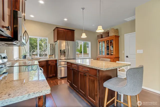 a kitchen with stainless steel appliances granite countertop wooden cabinets sink and stove