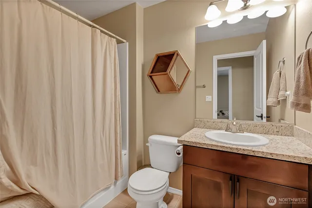 a bathroom with a granite countertop sink vanity mirror and toilet