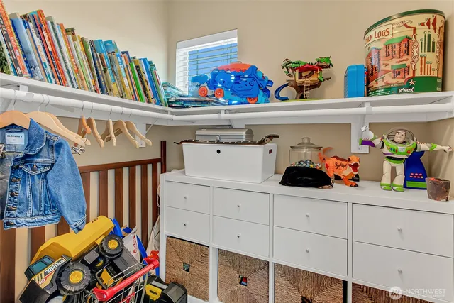 a group of people sitting in a bedroom with clothes and shoes