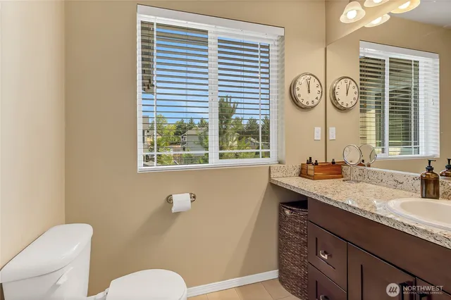 a bathroom with a granite countertop sink and a large mirror