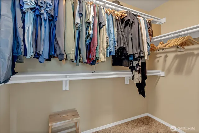 a view of walk in closet with clothes