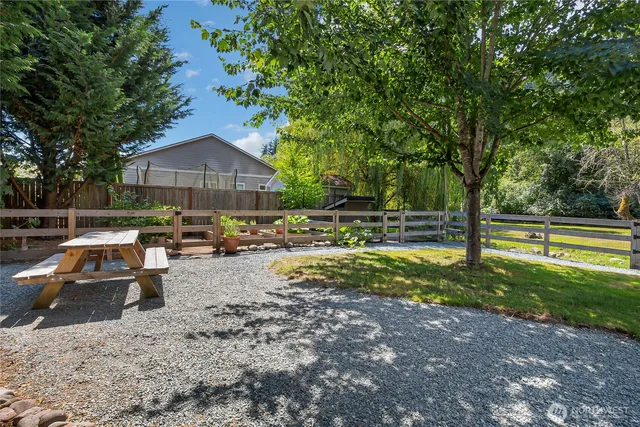 a view of backyard with swimming pool and seating space