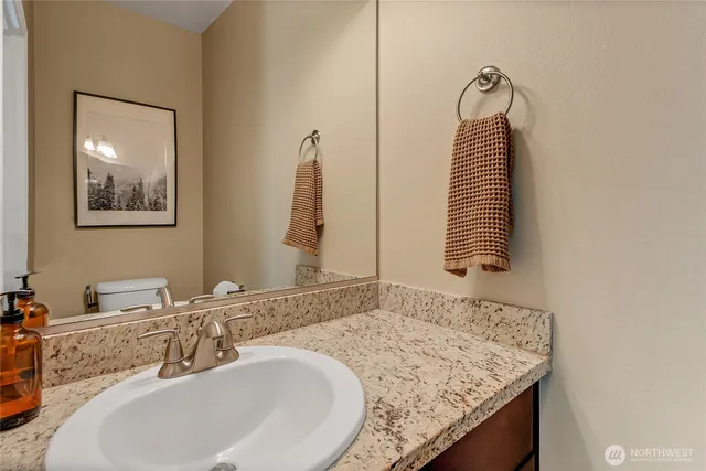 a bathroom with a granite countertop sink and a mirror